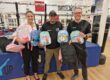 Lindleys and Switch Up team members holding new children's backpacks at the Nottingham School of Boxing gym