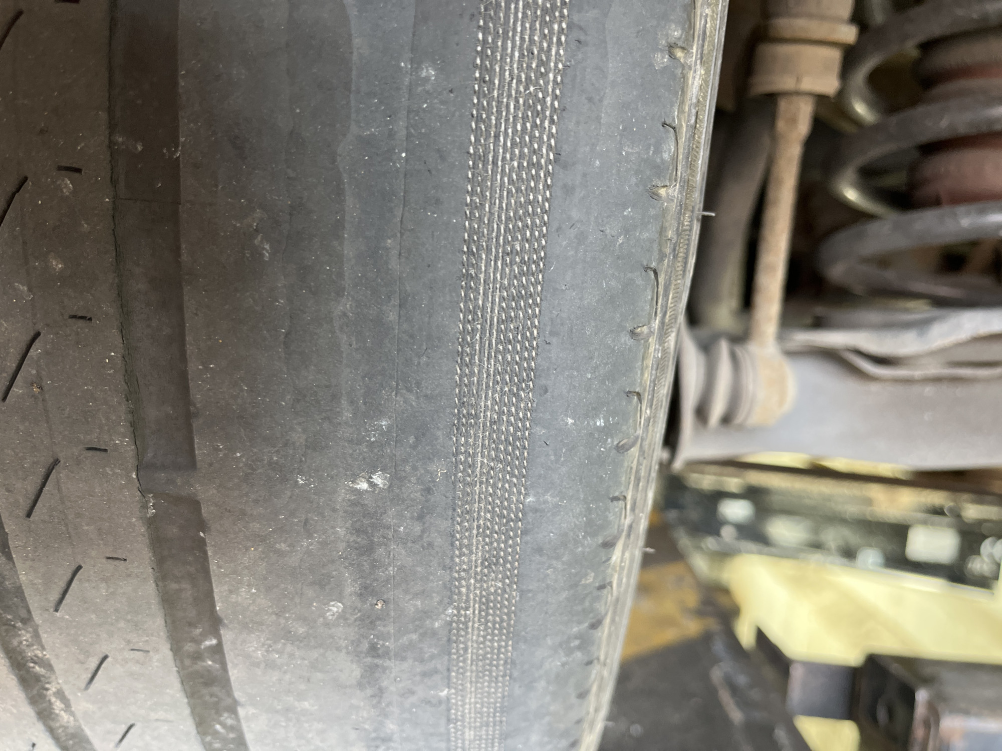 Tyre with the tread worn away on the inner shoulder exposing the cords