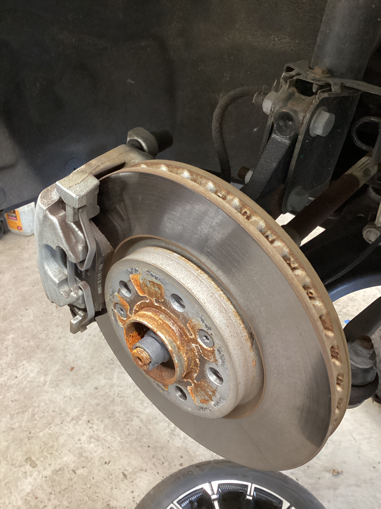 Rear brake disc and caliper in noticeably cleaner condition with an even braking surface