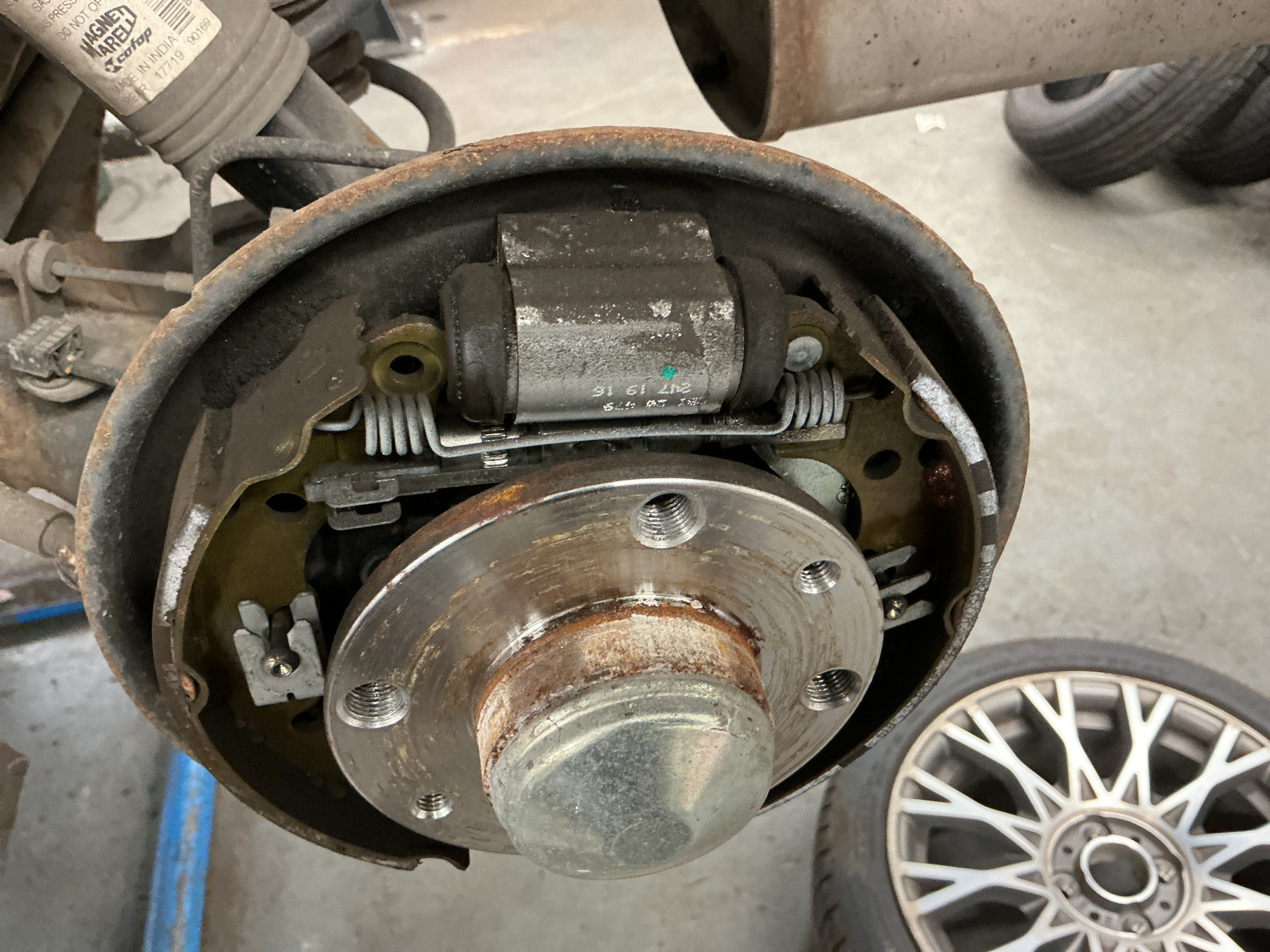 Rear drum brake assembly showing brake shoes, wheel cylinder, springs and self-adjuster mechanism