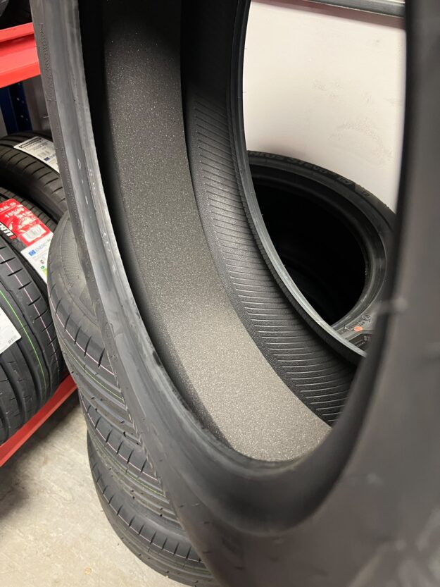 Cutaway view of an EV tyre showing the grey acoustic foam strip bonded inside the tread area