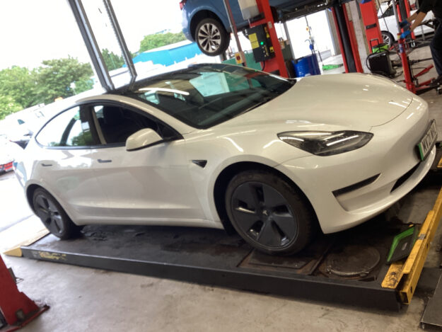 White Tesla Model 3 on the ramp inside the Lindleys Autocentres workshop in Nottinghamshire