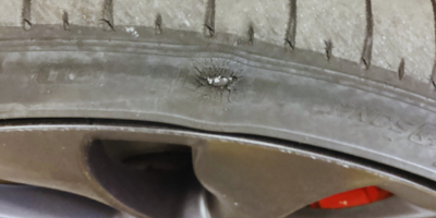 Close-up of damage to the sidewall shoulder of a Tesla tyre found during an MOT inspection