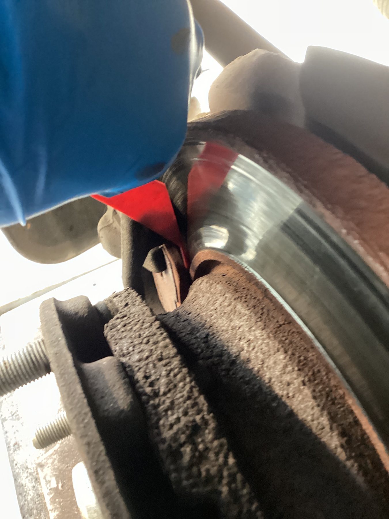 Brake pad wear gauge measuring remaining friction material against the disc