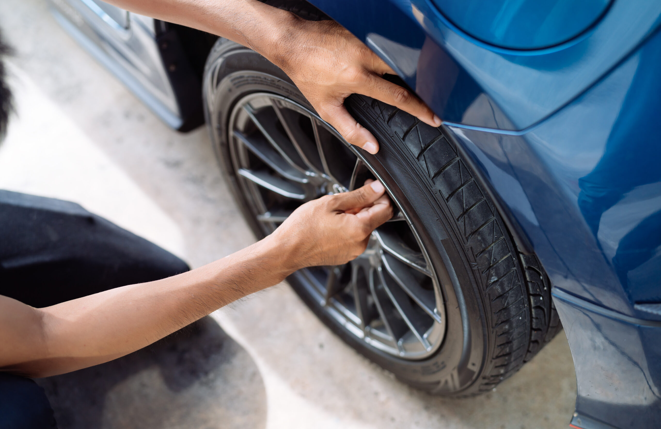 Technician checking a tyre on a car wheel