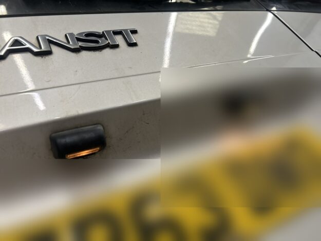 Two number plate lamps above the rear plate of a van's tailgate