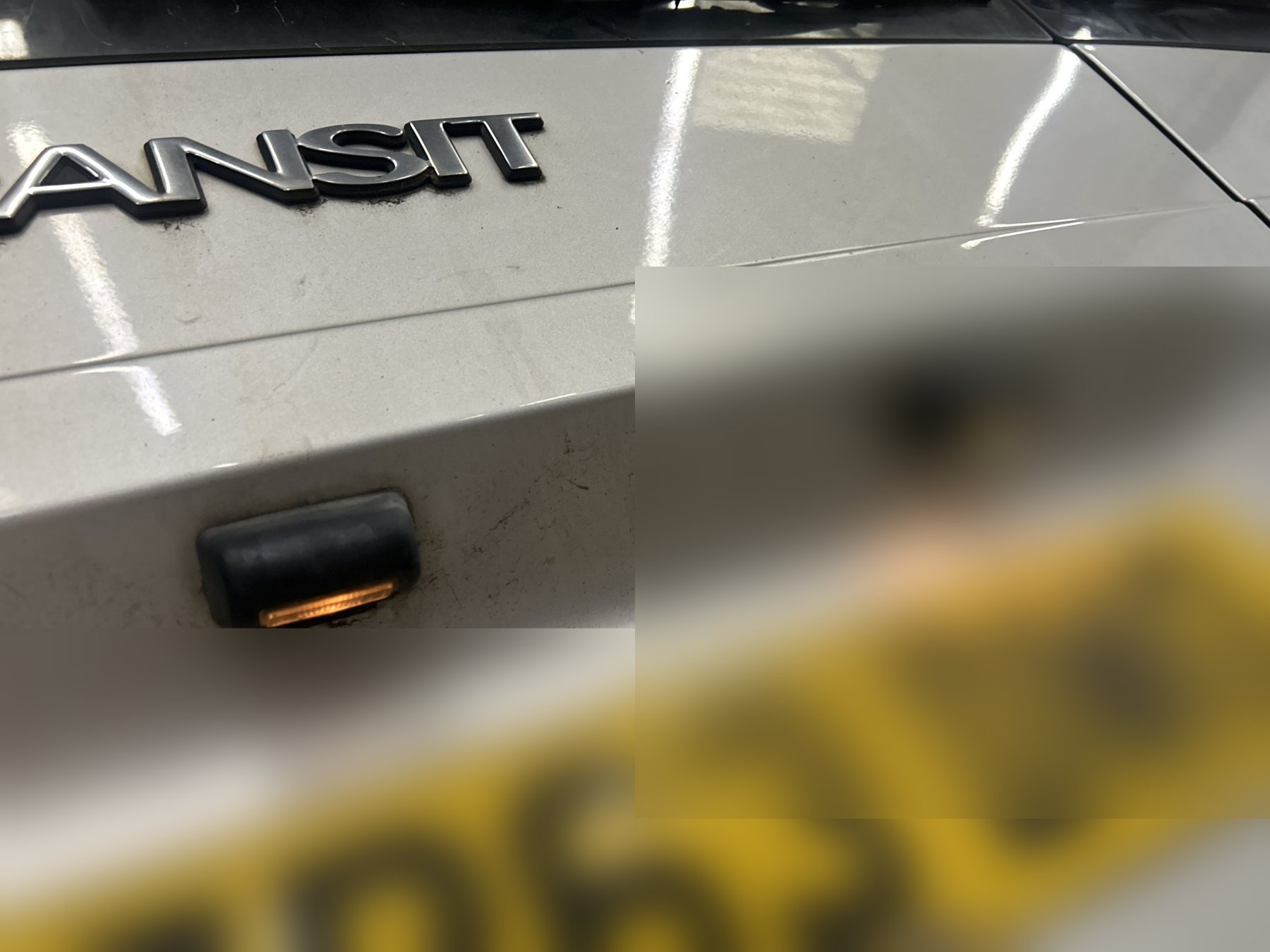 Two number plate lamps above the rear plate of a van's tailgate