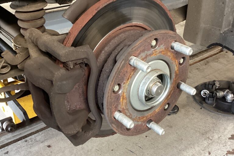 worn-corroded-brake-disc-wheel-off Wheel removed showing a worn brake disc with heavy corrosion and a pronounced lip