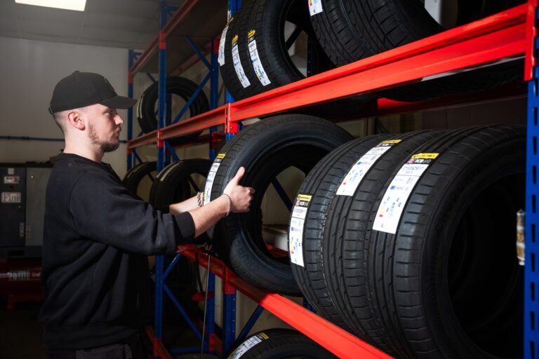 lindleys-technician-churchill-tyres-stock-rack Lindleys technician taking a tyre from a rack of Churchill tyres in stock