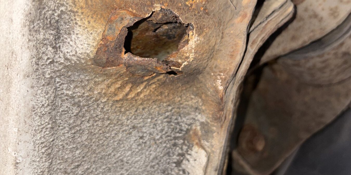 Rear sill corroded through with a hole near the suspension mounting