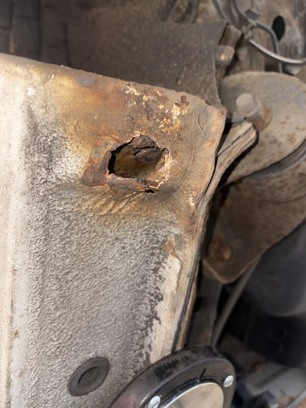 Rear sill corroded through with a hole near the suspension mounting