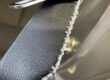 Seat belt webbing with a frayed, cut edge beside the buckle tongue